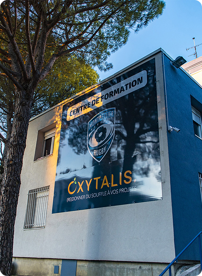 Devanture de l'école, on y voit une grande plaque métallique où figure l'inscription centre de formation aux côtés du logo du MHR et d'Oxytalis Campus