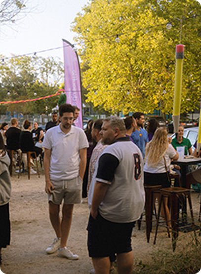 Photographie d'étudiants pendant un rassemblement extérieux. Des groupes sont formés et chacun passe un bon temps autour de tables.